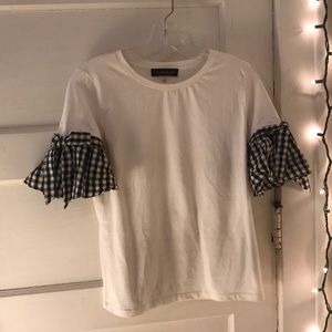 White T-shirt with plaid bow tie sleeves.